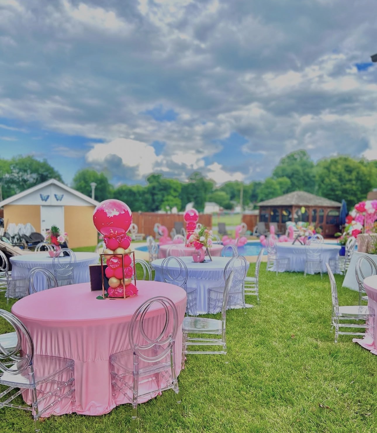Poolside birthday celebration with floral backdrop and balloon arch